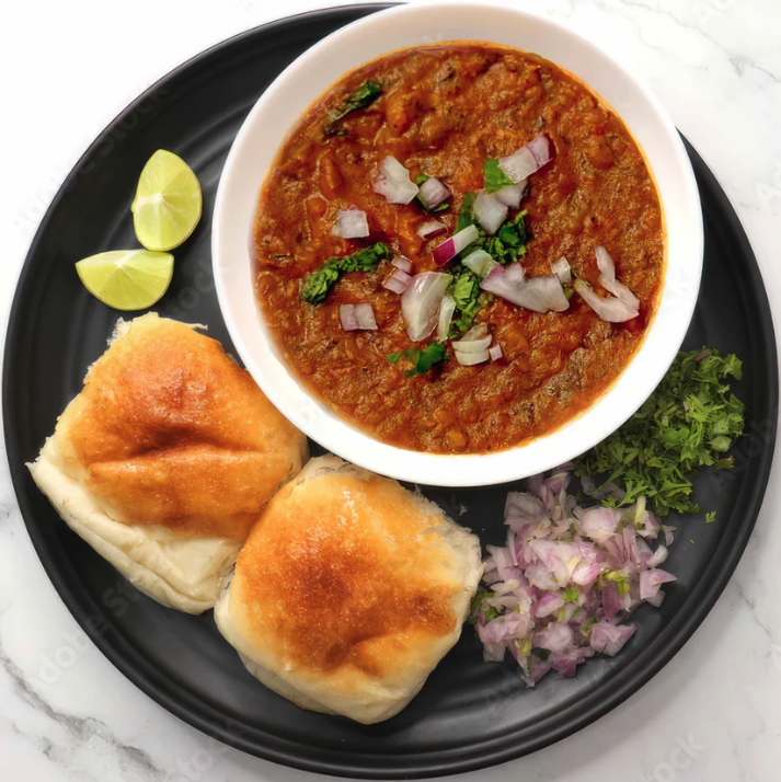 Pav bhaji with buttered pav and garnishes